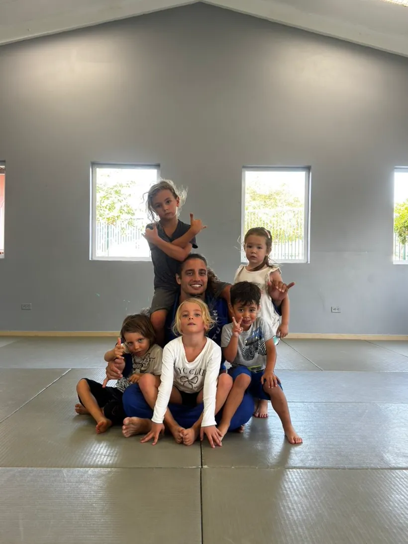 Holmes coach with his youngest students on the mat