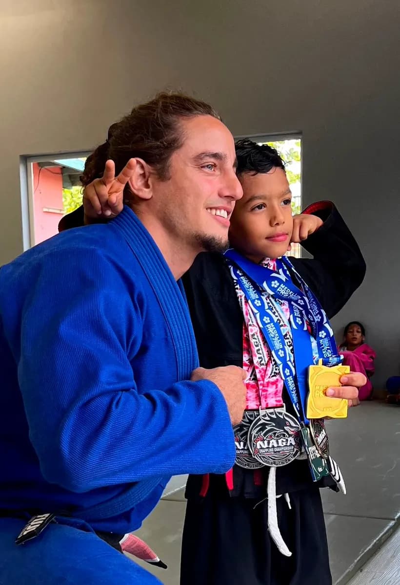 Holmes coach with a young student wearing NAGA and Medellin Pro medals
